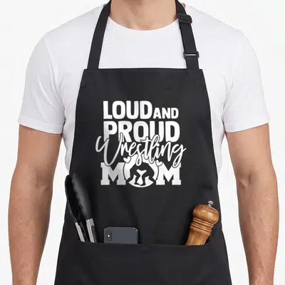Proud wrestling apron - White LOUD AND PROUD Wrestling MOM text with headgear icon and two hearts — shown on a black cotton canvas apron against a white background