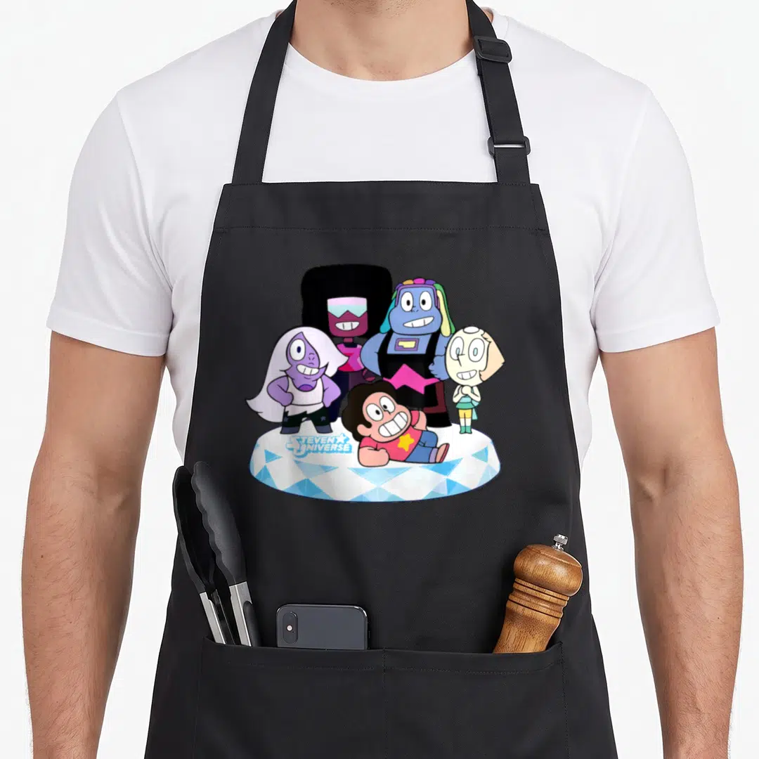 Steven muffins apron - Four cartoon gems on blue platform with STEVEN UNIVERSE logo text — shown on a black cotton canvas apron against a white background