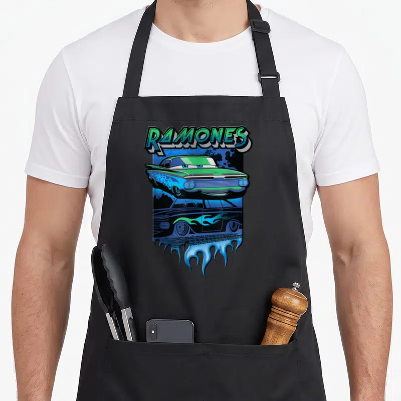 Ramone car apron - Green and blue cartoon lowrider with RAMONES text and blue flames — shown on a black cotton canvas apron against a white background