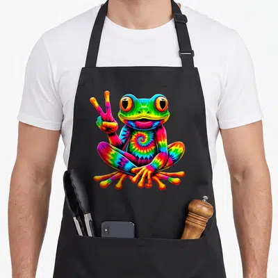 Frog tie-dye apron - Rainbow tie-dye frog sitting and holding up a peace sign in cartoon style — shown on a black cotton canvas apron against a white background