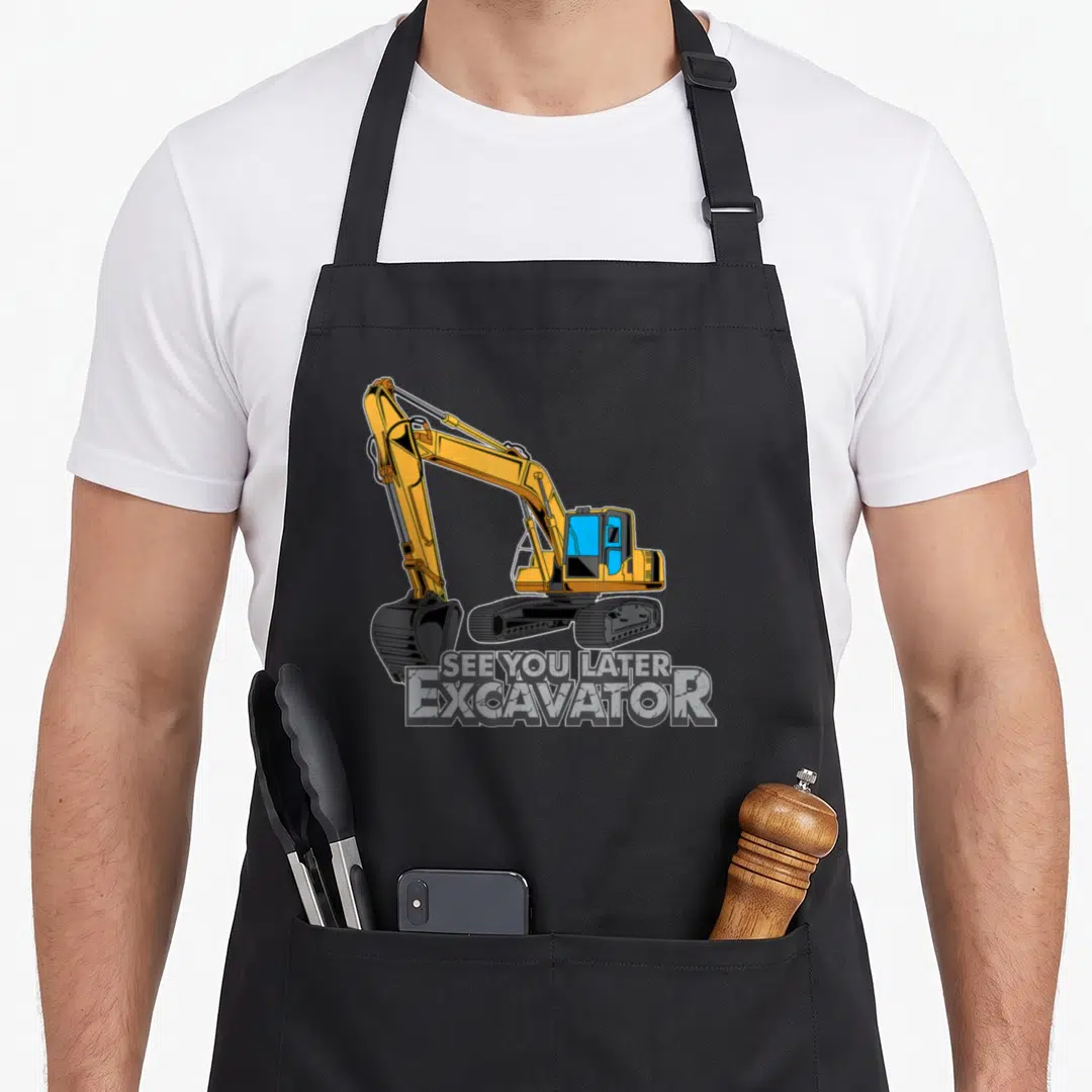 Toddler excavator girl apron - Cartoon yellow excavator above SEE YOU LATER EXCAVATOR text in block letters — shown on a black cotton canvas apron against a white background