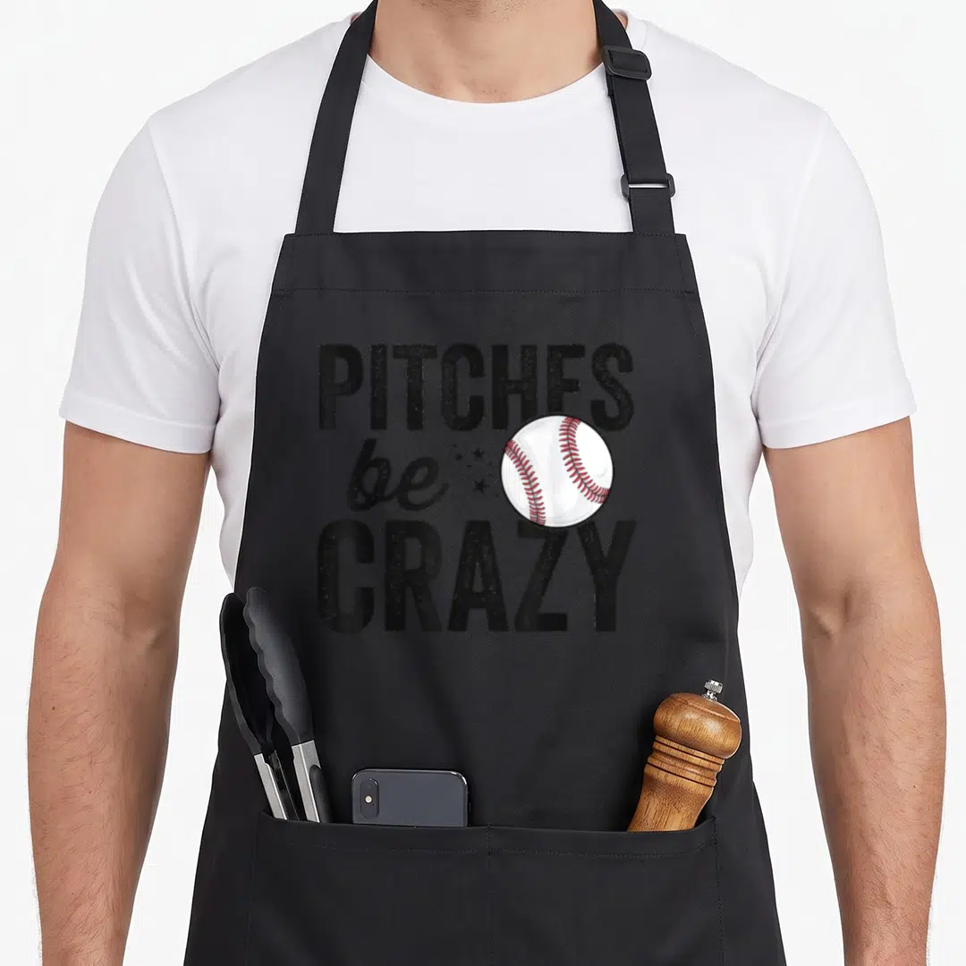 Funny pitch baseball apron - PITCHES be CRAZY text with baseball and stars in black white and red — shown on a black cotton canvas apron against a white background