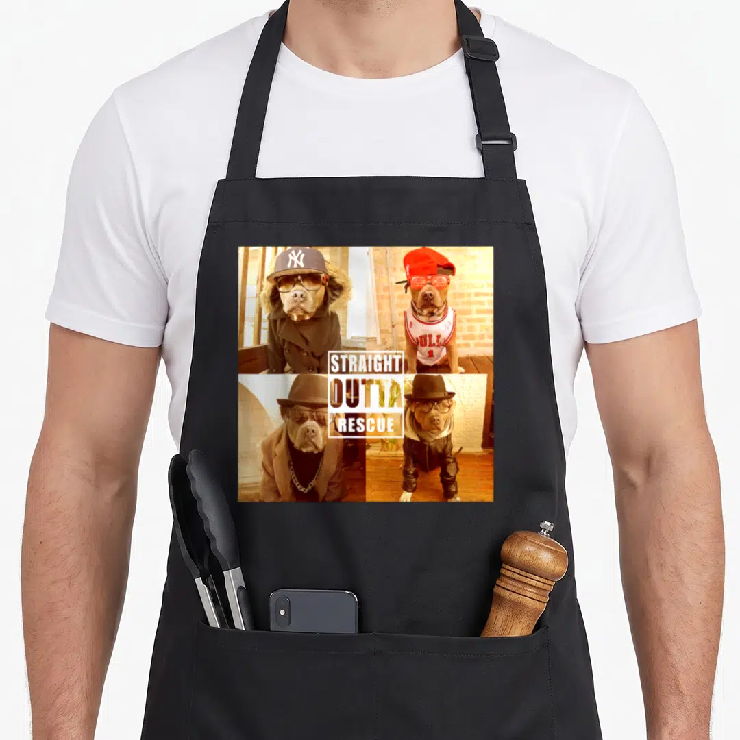 Straight pit bull apron - Four dog photos in outfits with central white box reading STRAIGHT OUTTA RESCUE — shown on a black cotton canvas apron against a white background