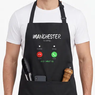 Manchester england apron - Smartphone call screen with MANCHESTER is calling text and red and green buttons — shown on a black cotton canvas apron against a white background