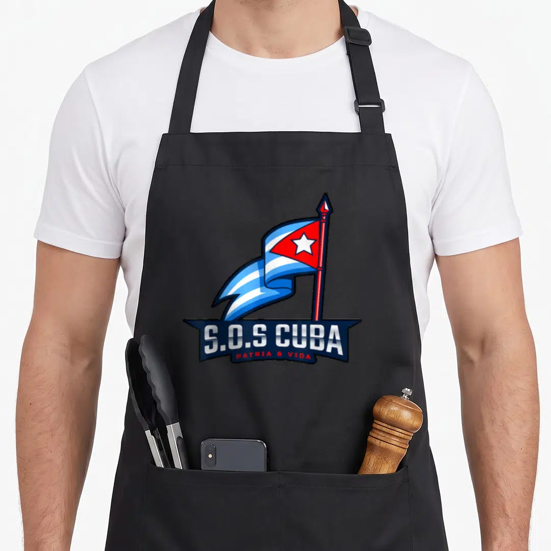 Cubano cuba libre apron - Cartoon Cuban flag on pole above dark banner with S.O.S CUBA PATRIA & VIDA text — shown on a black cotton canvas apron against a white background