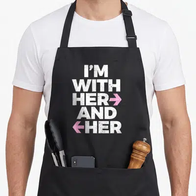 Throuple her apron - Stacked white text I'M WITH HER AND HER with pink right and left arrows distressed finish — shown on a black cotton canvas apron against a white background