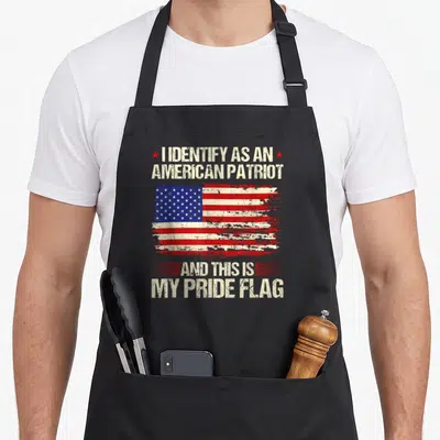 Pride american flag apron - Distressed US flag between text reading I IDENTIFY AS AN AMERICAN PATRIOT AND THIS IS MY — shown on a black cotton canvas apron against a white background