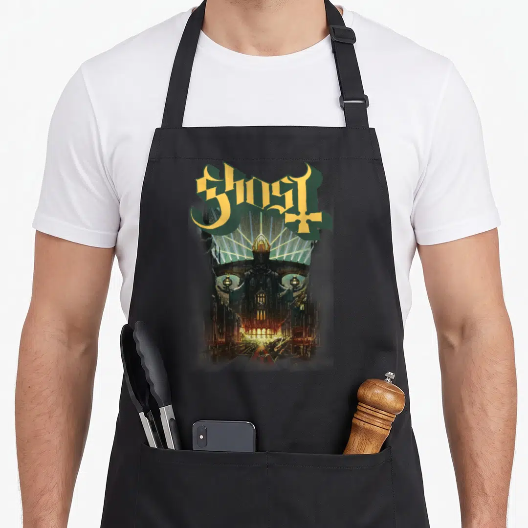 Meliora ghost apron - GHOST text in yellow over grey cathedral with blue light rays and skull detail — shown on a black cotton canvas apron against a white background