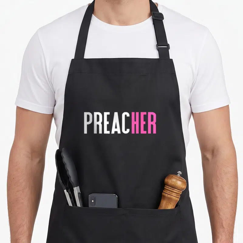 Funny preacher apron - White and pink PREACHER text on grey background with two front pockets — shown on a black cotton canvas apron against a white background