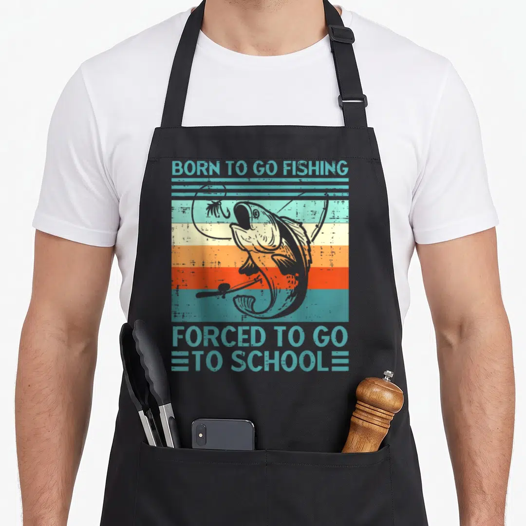 School fishing aprons - Retro fish and rod over teal orange stripes withBorn to Go Fishing Forced to School text — shown on a black cotton canvas apron against a white background