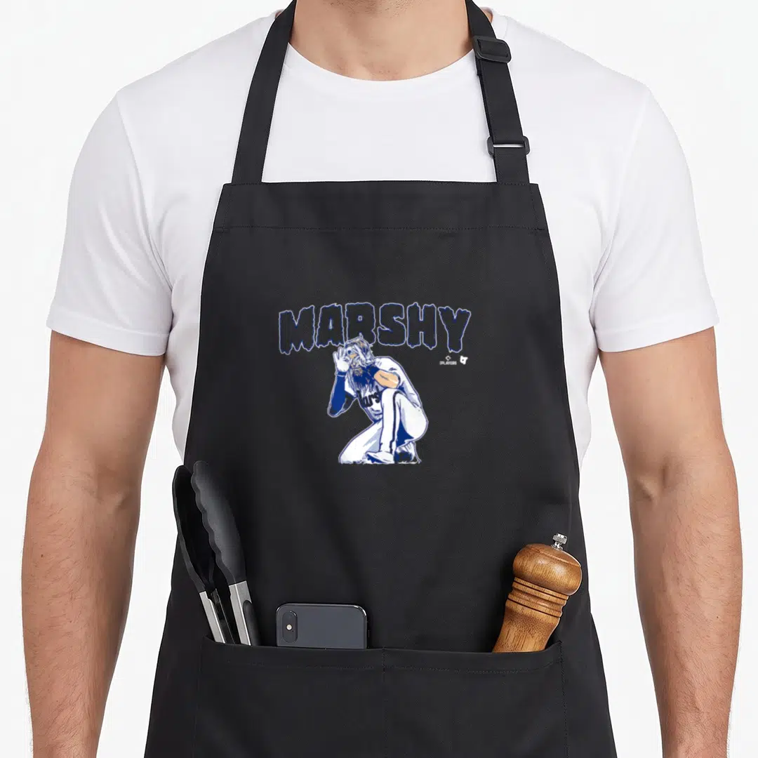 Brandon baseball apron - MARSHY text arched over blue and white kneeling man cartoon illustration — shown on a black cotton canvas apron against a white background