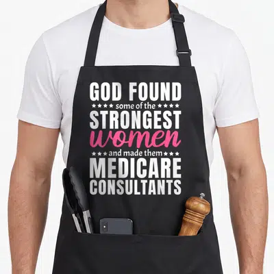Funny medicare consultant apron - Stacked white and pink text reading God found strongest women made them Medicare — shown on a black cotton canvas apron against a white background