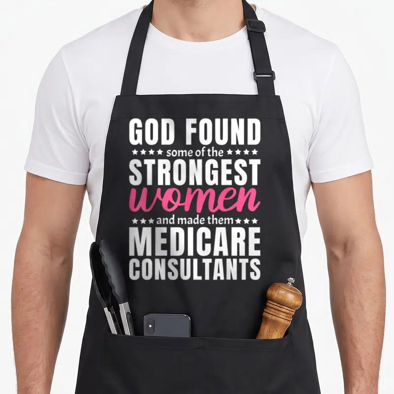 Funny medicare consultant apron - Stacked white and pink text reading God found strongest women made them Medicare — shown on a black cotton canvas apron against a white background