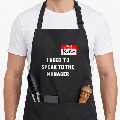Karen costume speak halloween apron - Red name tag reading Hello My Name Is Karen above white text I need to speak — shown on a black cotton canvas apron against a white background