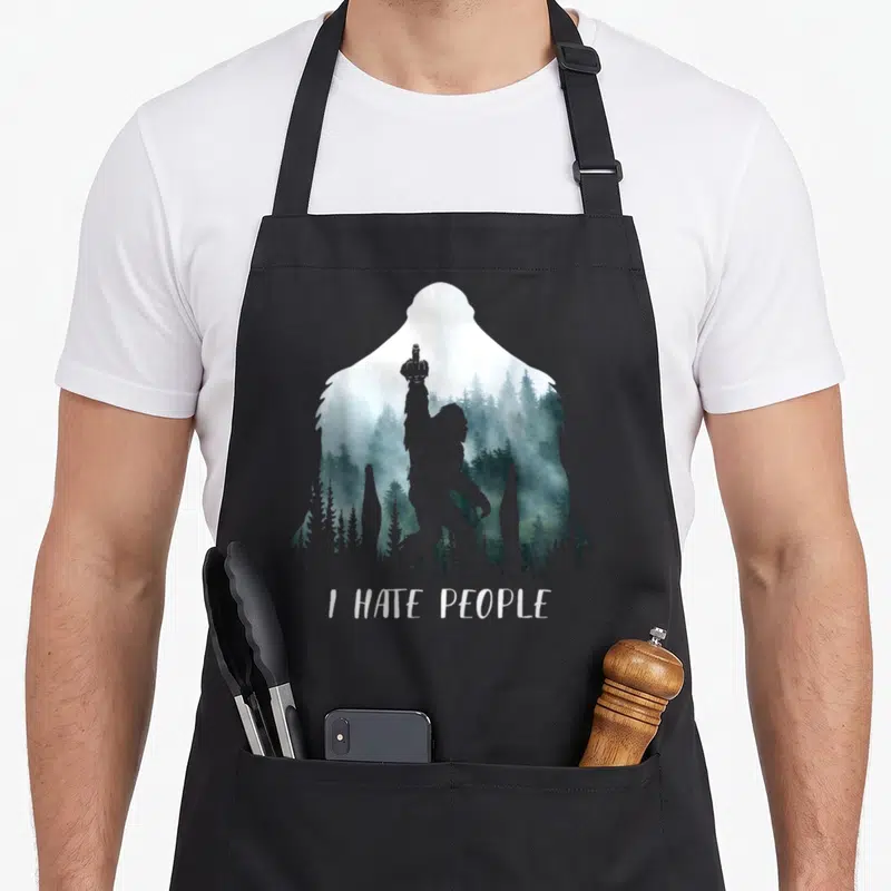 Hate bigfoot camping apron - Bigfoot silhouette filled with misty forest and I HATE PEOPLE text — shown on a black cotton canvas apron against a white background