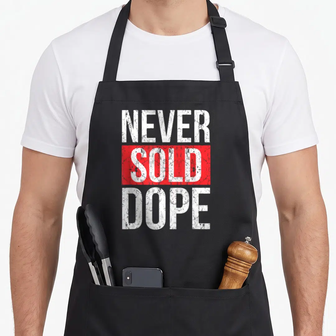 Sold hip apron - Stacked NEVER SOLD DOPE text with red bar and distressed white lettering — shown on a black cotton canvas apron against a white background