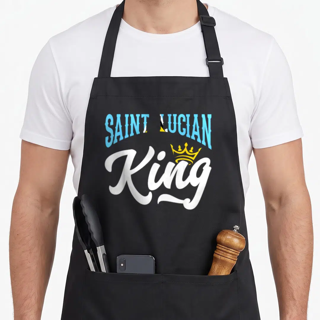 Saint king apron - Arched blue Saint Lucian text over white King script with yellow crown — shown on a black cotton canvas apron against a white background