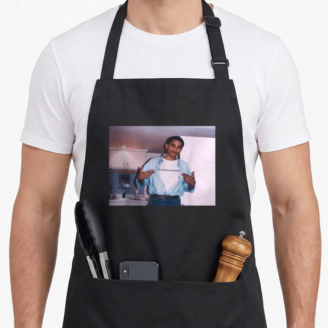 President madison alabama apron - Man in blue shirt pointing to THE AMERICAN DREAM text on white tee — shown on a black cotton canvas apron against a white background