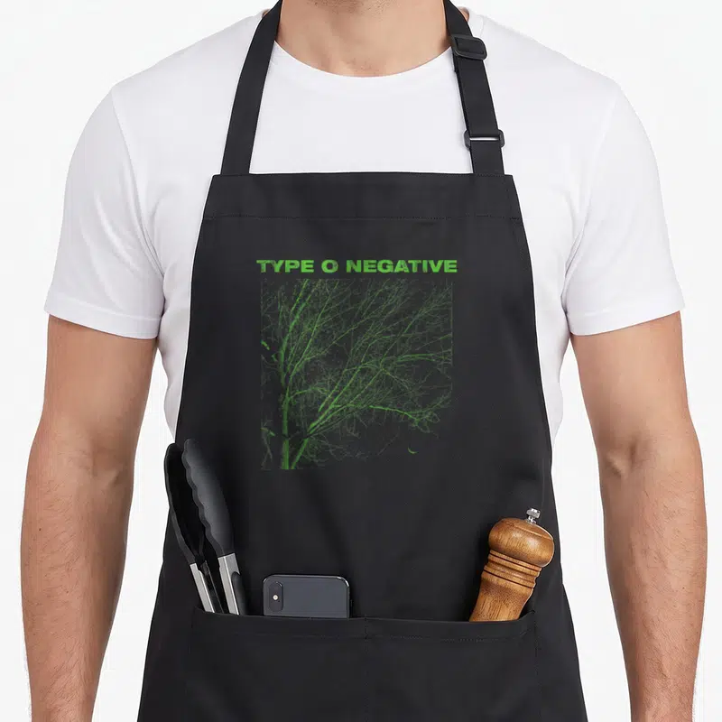 Negative tree apron - Green TYPE O NEGATIVE text above bare green tree branches on grey background — shown on a black cotton canvas apron against a white background
