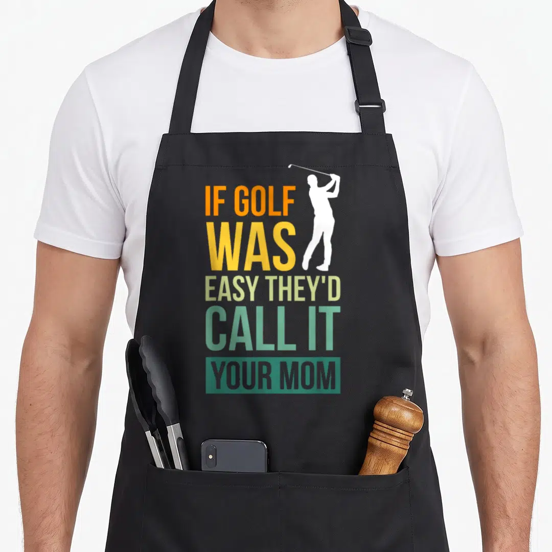 Theyd call golf apron - Stacked colorful text reading If Golf Was Easy They'd Call It Your Mom next to a white golfer — shown on a black cotton canvas apron against a white background