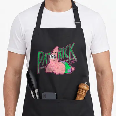 Sweet patricks apron - Patrick Star cartoon character with green PATRICK and pink STAR text on black fabric — shown on a black cotton canvas apron against a white background