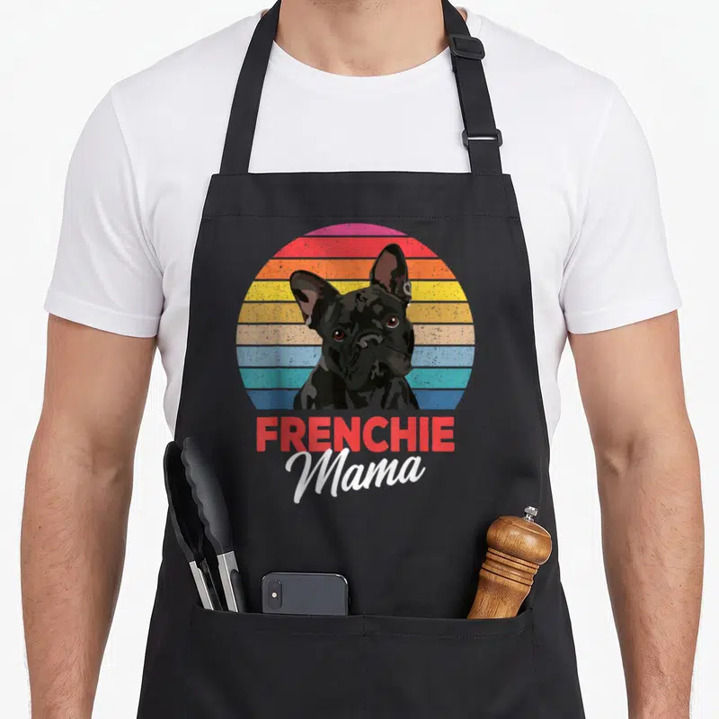 Mama french apron - Retro black French Bulldog on multi-colored striped circle with FRENCHIE Mama text — shown on a black cotton canvas apron against a white background
