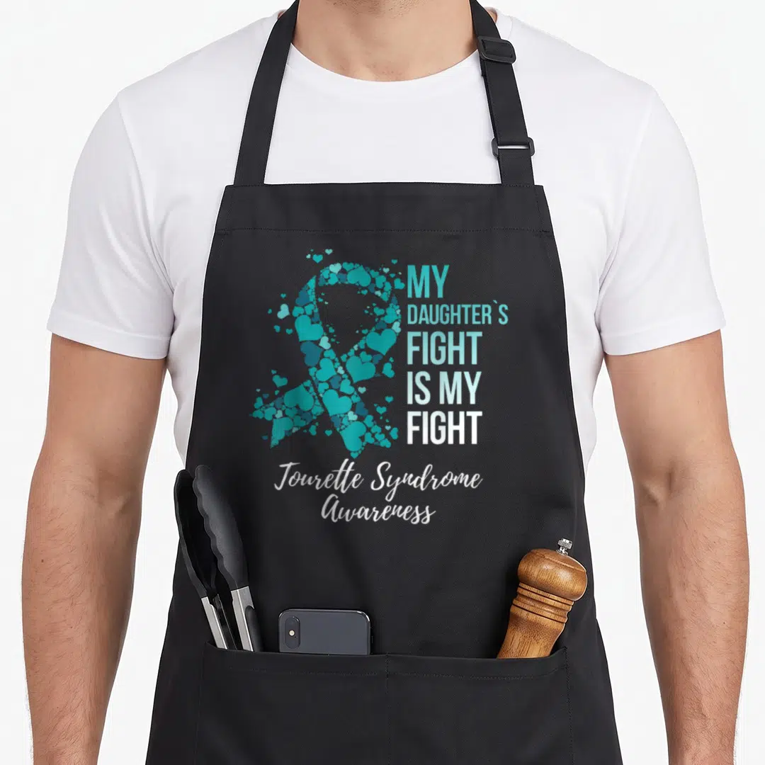 Daughter tourette awareness apron - Teal heart ribbon next to stacked text My Daughter's Fight Is My Fight with white — shown on a black cotton canvas apron against a white background