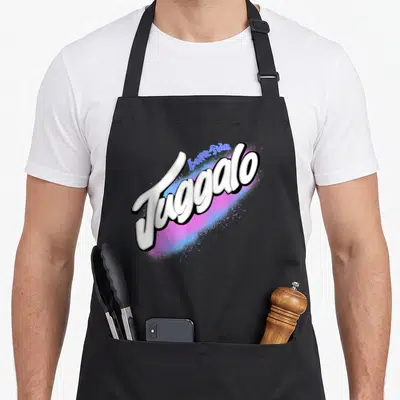 Delicious streetwear apron - bona-fide Juggalo white script text over pink and blue spray paint graphic — shown on a black cotton canvas apron against a white background