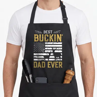 Buckin hunter apron - Stacked text over distressed flag with two deer silhouettes in yellow and white — shown on a black cotton canvas apron against a white background