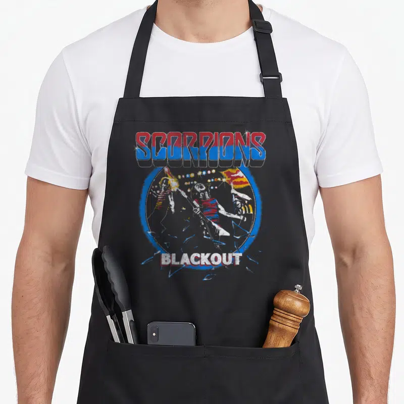 Live scorpion apron - SCORPIONS BLACKOUT text with band members and shattering guitar in red blue white — shown on a black cotton canvas apron against a white background
