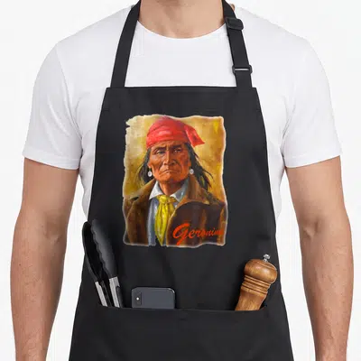 Apache native american apron - Realistic portrait of Geronimo with red headwrap and script name on textured background — shown on a black cotton canvas apron against a white background