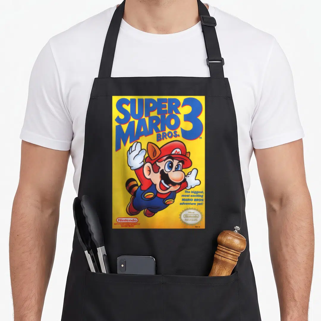 Bro flying apron - Raccoon Mario flying on yellow Super Mario Bros 3 box cover art — shown on a black cotton canvas apron against a white background