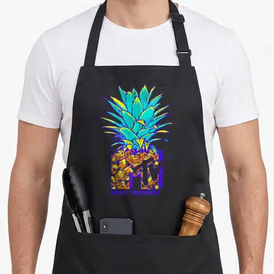 Mtv pineapple apron - Colorful cartoon pineapple behind purple MTV logo with MUSIC TELEVISION text below — shown on a black cotton canvas apron against a white background