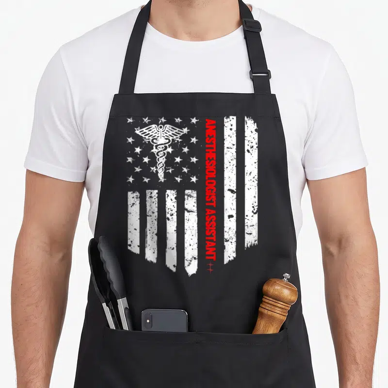 Anesthesiologist american flag apron - Distressed white caduceus over stars with vertical red ANESTHESIOLOGIST — shown on a black cotton canvas apron against a white background