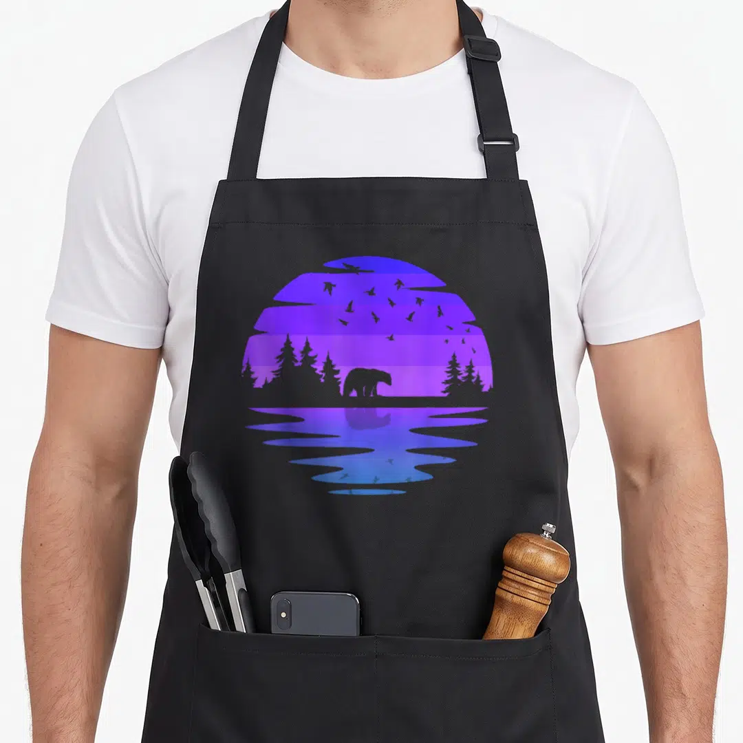 Outdoor birds apron - Minimalist bear and trees in circular blue purple violet striped design with water reflection — shown on a black cotton canvas apron against a white background