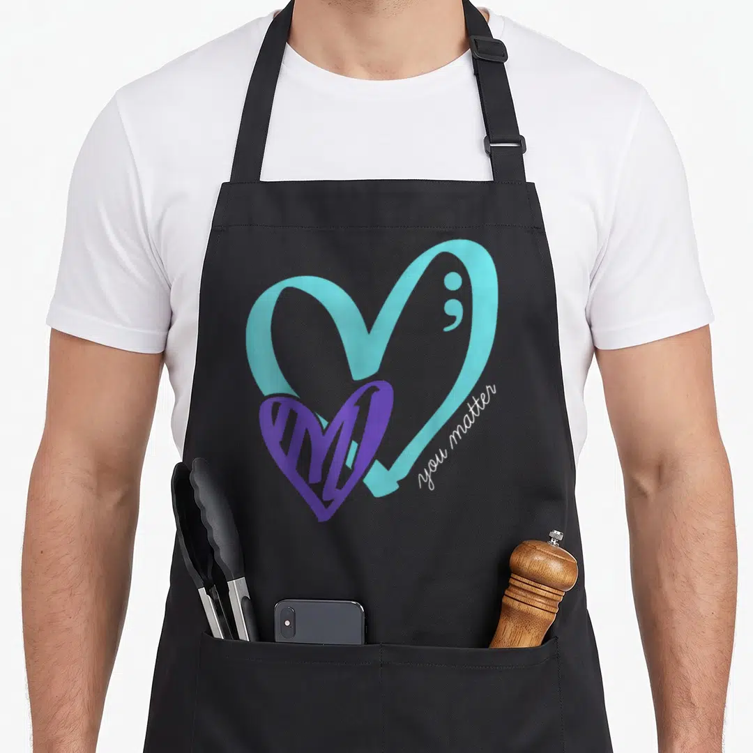 Matter depression awareness apron - Light blue heart with semicolon, overlapping purple heart, white you matter script — shown on a black cotton canvas apron against a white background