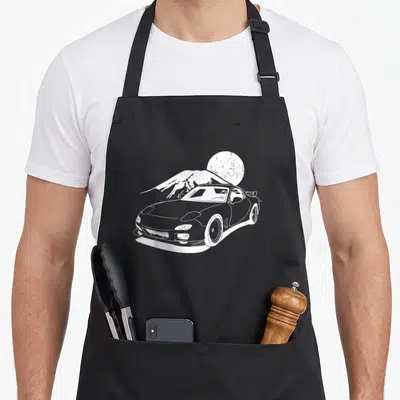 Motorsport japan apron - White line-art tuning car silhouette in front of a mountain and textured sun circle — shown on a black cotton canvas apron against a white background