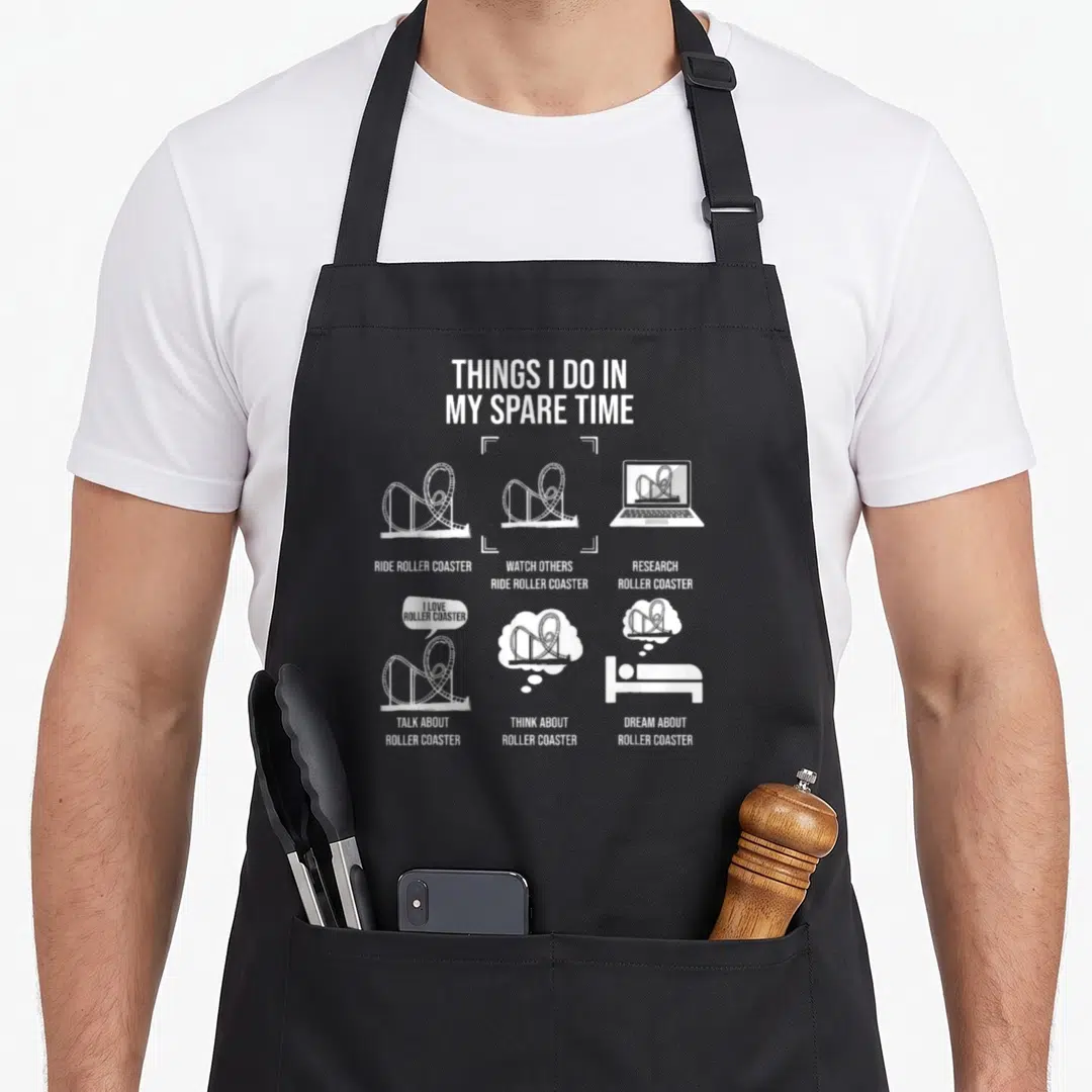 Spare theme aprons - White text and icons listing roller coaster activities on a black apron — shown on a black cotton canvas apron against a white background