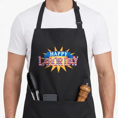 Five labor day apron - HAPPY LABOR DAY text in blue ribbon and red white stripes on yellow starburst — shown on a black cotton canvas apron against a white background