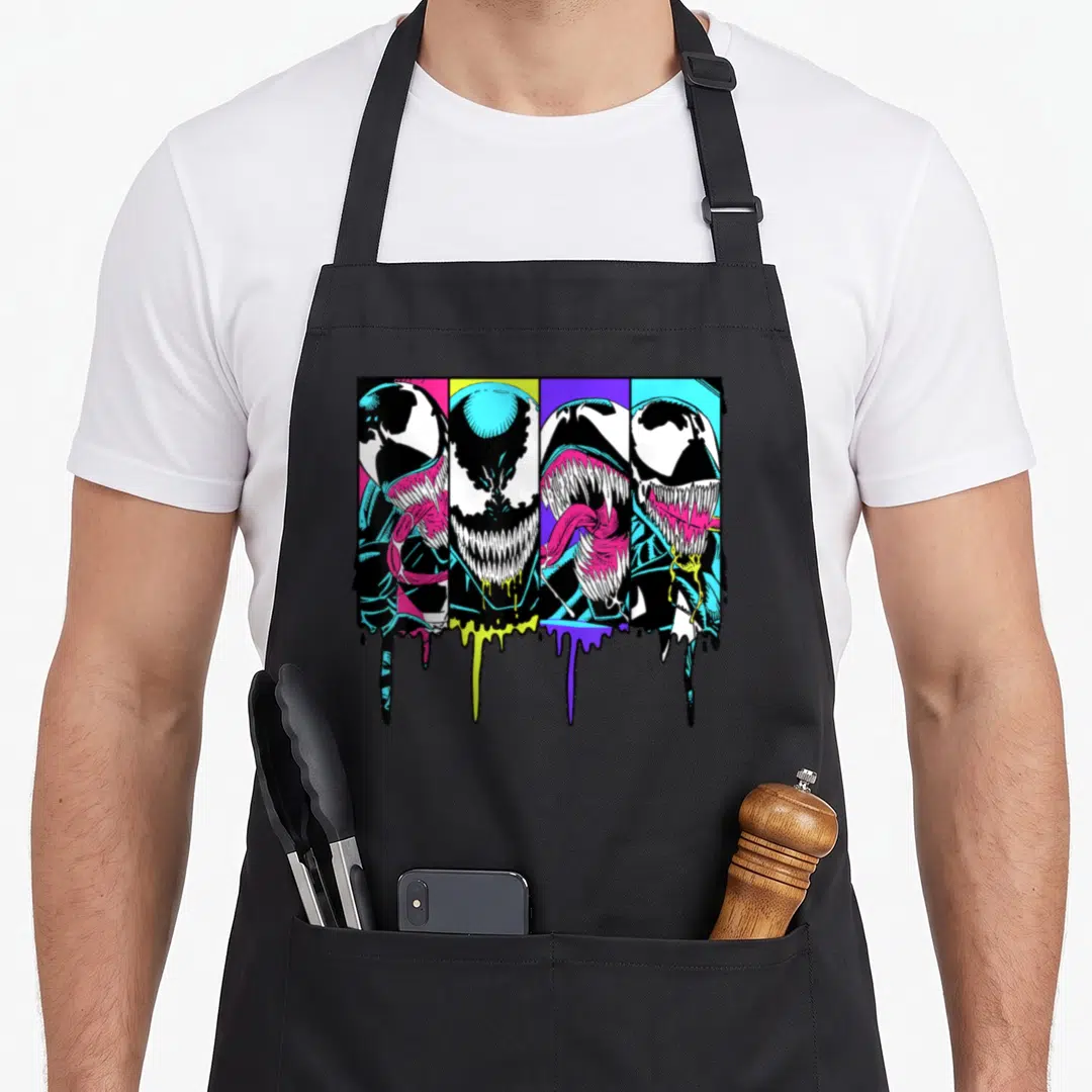 Dripping colorful apron - Four Venom heads in vertical panels with dripping paint in black, white, pink, yellow — shown on a black cotton canvas apron against a white background