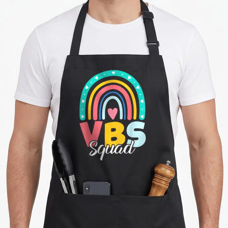 Vbs squad teacher apron - Cartoon rainbow with white and pink hearts above multi-colored VBS Squad lettering — shown on a black cotton canvas apron against a white background