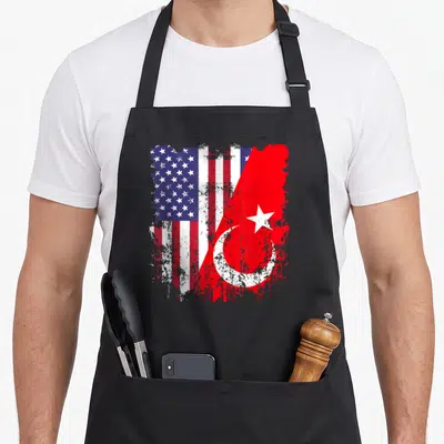 Turkish american flag apron - Two flags merged side-by-side with distressed paint splatters in red white and blue — shown on a black cotton canvas apron against a white background