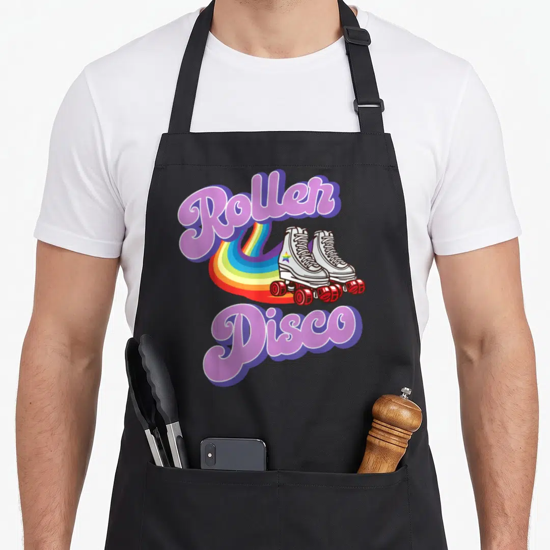 Roller disco 70s apron - Purple Roller Disco text with white skates and rainbow trail — shown on a black cotton canvas apron against a white background