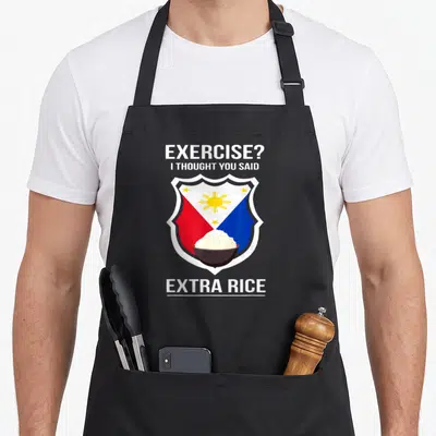 Filipina food aprons - Exercise extra rice pun with Philippine flag shield and bowl of rice — shown on a black cotton canvas apron against a white background