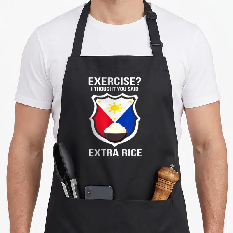 Filipina food aprons - Exercise extra rice pun with Philippine flag shield and bowl of rice — shown on a black cotton canvas apron against a white background