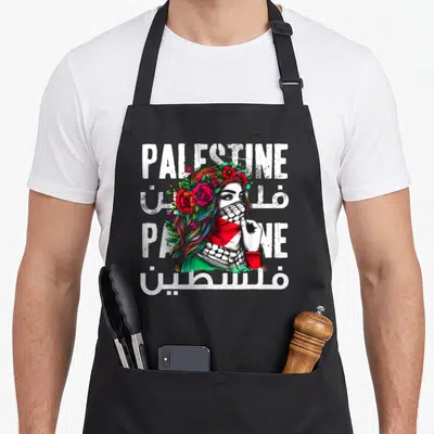 Bandana palestinian apron - Woman in keffiyeh and flower crown with PALESTINE text in English and Arabic — shown on a black cotton canvas apron against a white background