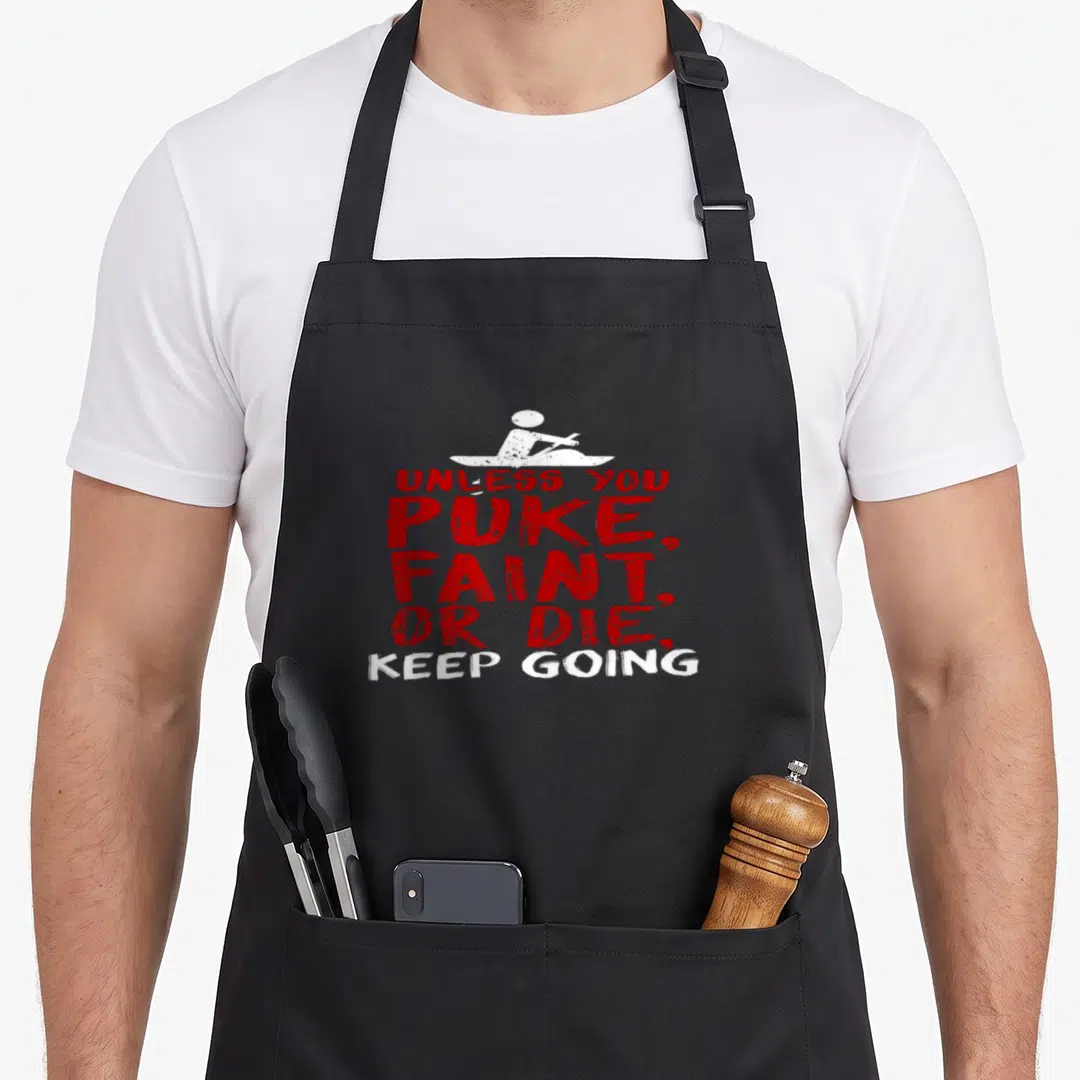 Unless apron or apron - White kayaker silhouette above stacked red and white text unless you puke faint or die keep — shown on a black cotton canvas apron against a white background