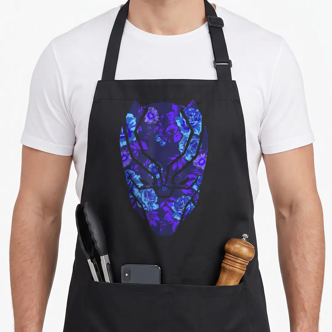 Mask floral apron - Black Panther mask silhouette filled with blue and purple flowers and leaves in a minimalist style — shown on a black cotton canvas apron against a white background