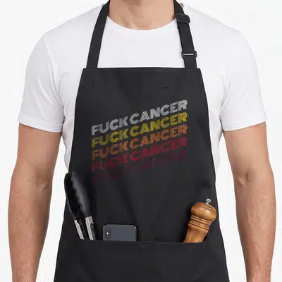 Cool breast cancer awareness aprons - Five stacked lines of FUCK CANCER in white yellow orange red maroon retro linear — shown on a black cotton canvas apron against a white background