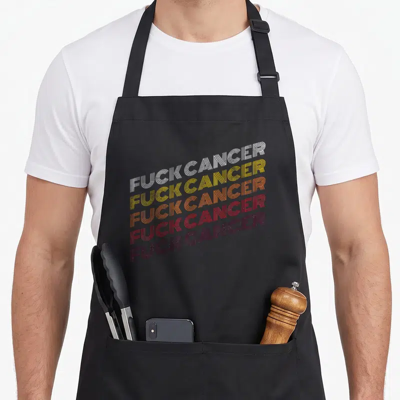 Cool breast cancer awareness aprons - Five stacked lines of FUCK CANCER in white yellow orange red maroon retro linear — shown on a black cotton canvas apron against a white background